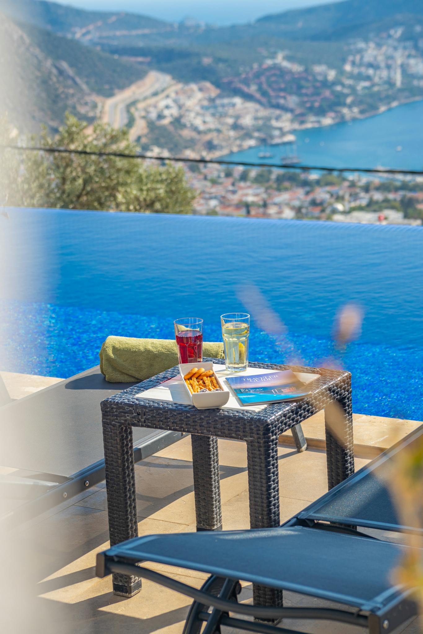 Relaxing poolside with stunning ocean and mountain views at a luxury resort.